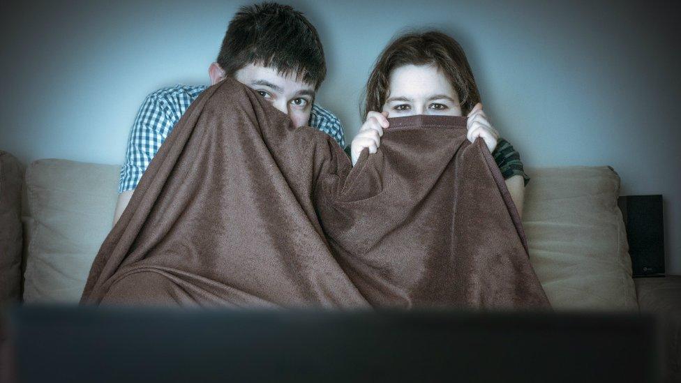 Children cowering in front of the television