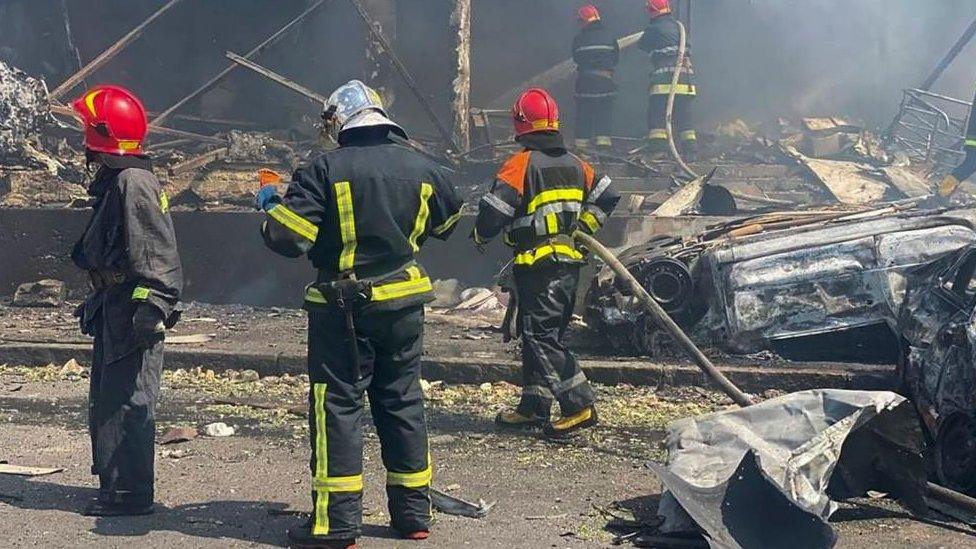 Five emergency services workers tackle a post-bomb fire