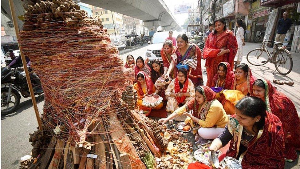 Devotees perform rituals during 'Holika Dahan' on the eve of Holi festival at Exhibition road on March 17, 2022 in Patna, India