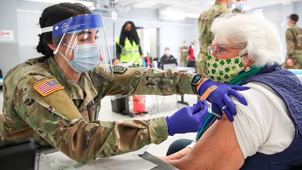 A US Army medic administers a coronavirus vaccine to an elderly woman at a vaccination centre in Illinois - 3 February 2021