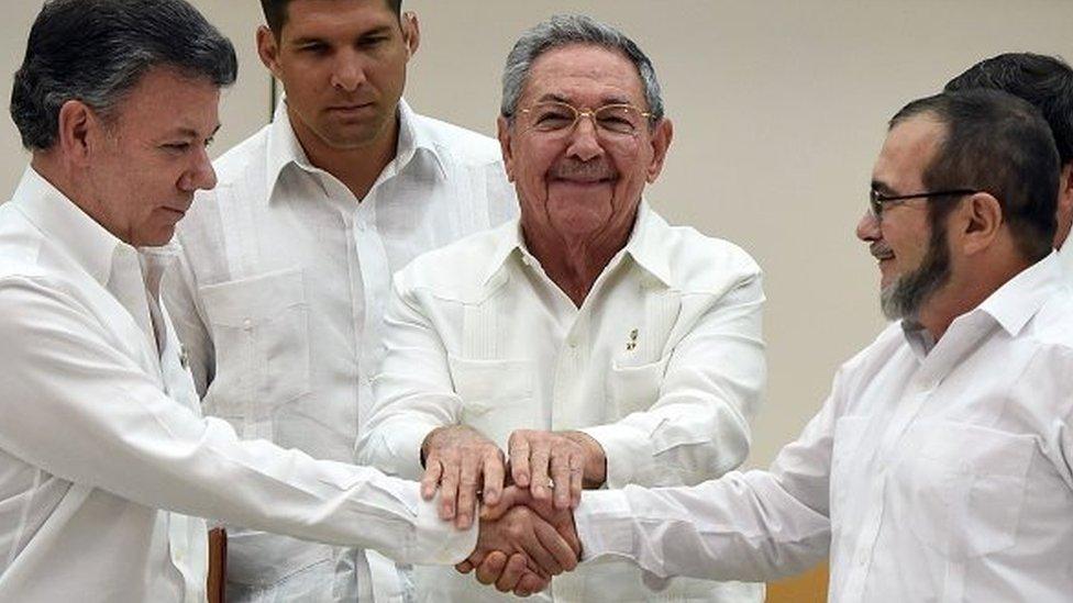 Colombian President Juan Manuel Santos (L) and the head of the FARC guerrilla Timoleon Jimenez, aka Timochenko (R), shake hands as Cuban President Raul Castro (C) holds their hands during a meeting in Havana on September 23, 2015.