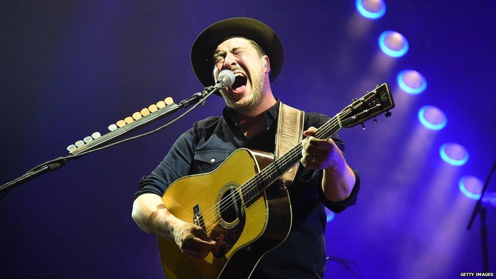 Marcus Mumford performing on stage