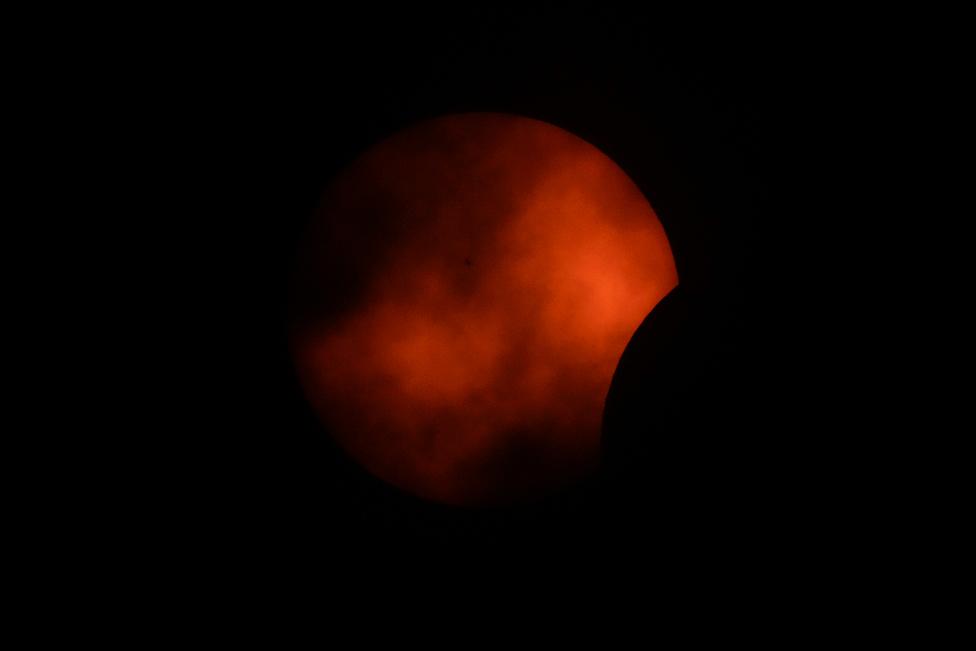 Clouds roll by as the beginning phase of a total solar eclipse is visible from Arlington, Texas, Monday, April 8, 2024. (AP Photo/Julio Cortez)