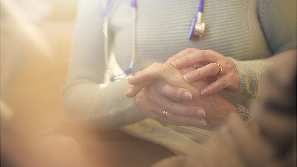 Doctor holding patient's hand