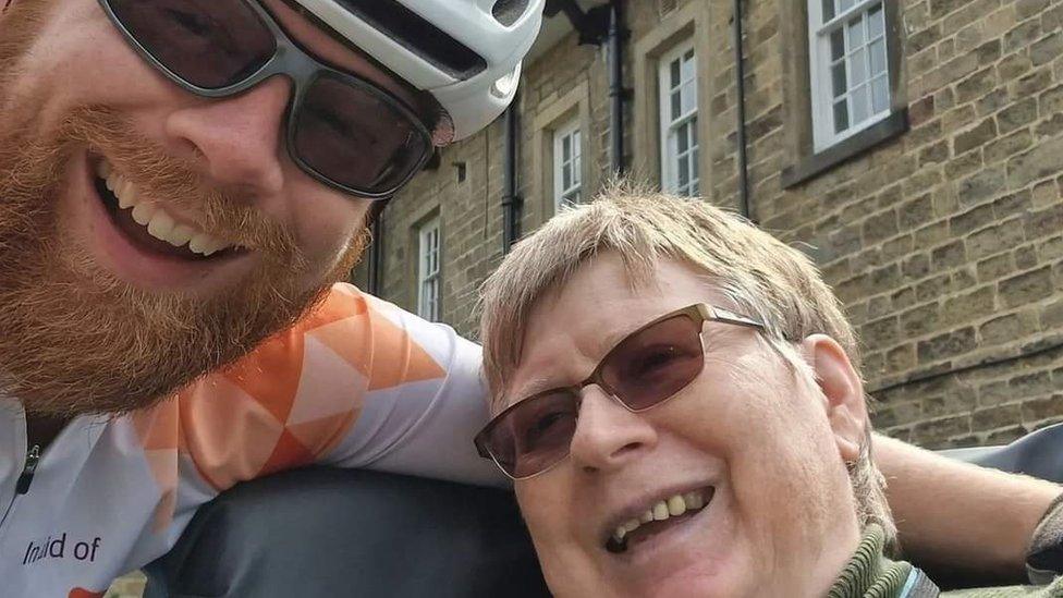 Picture of cyclist with his arm around his mother