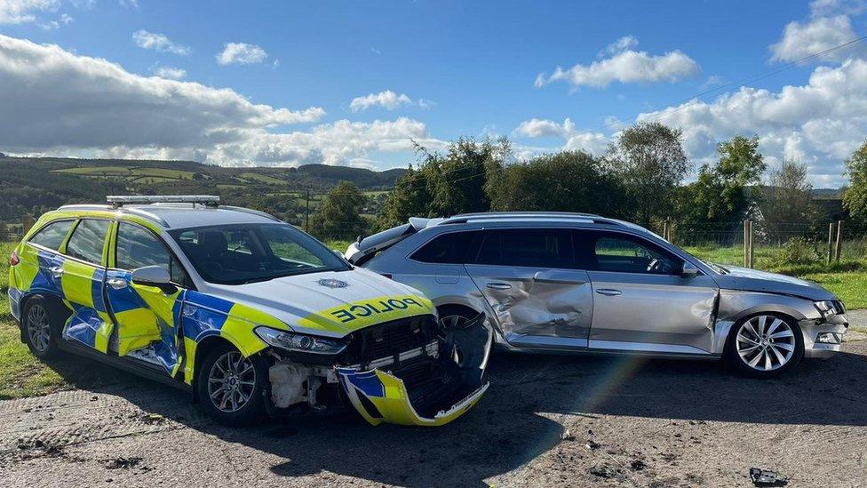 Police cars showing damage after being rammed by tractor