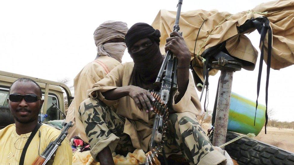 Militiaman from the Ansar Dine Islamic group sit on a vehicle in Gao in northeastern Mali in 2012