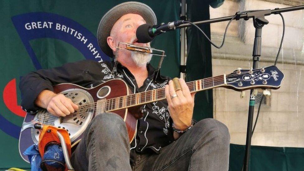 Busker playing instrument at music festival