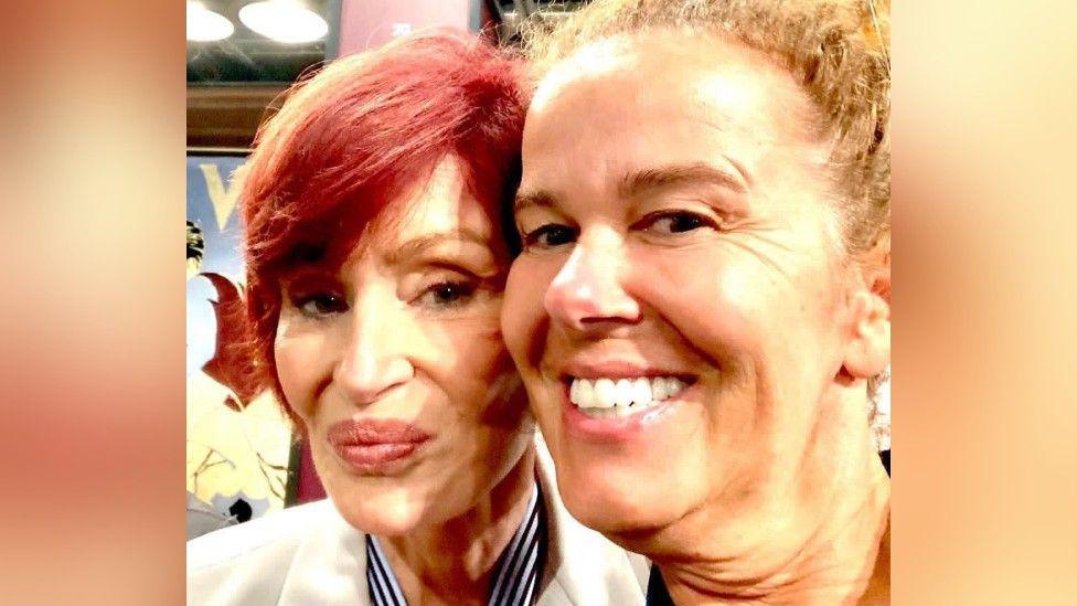 Sharon Osbourne smiles at the camera for a selfie, next to a blonde smiling woman, with the picture cropped to show their head and shoulders