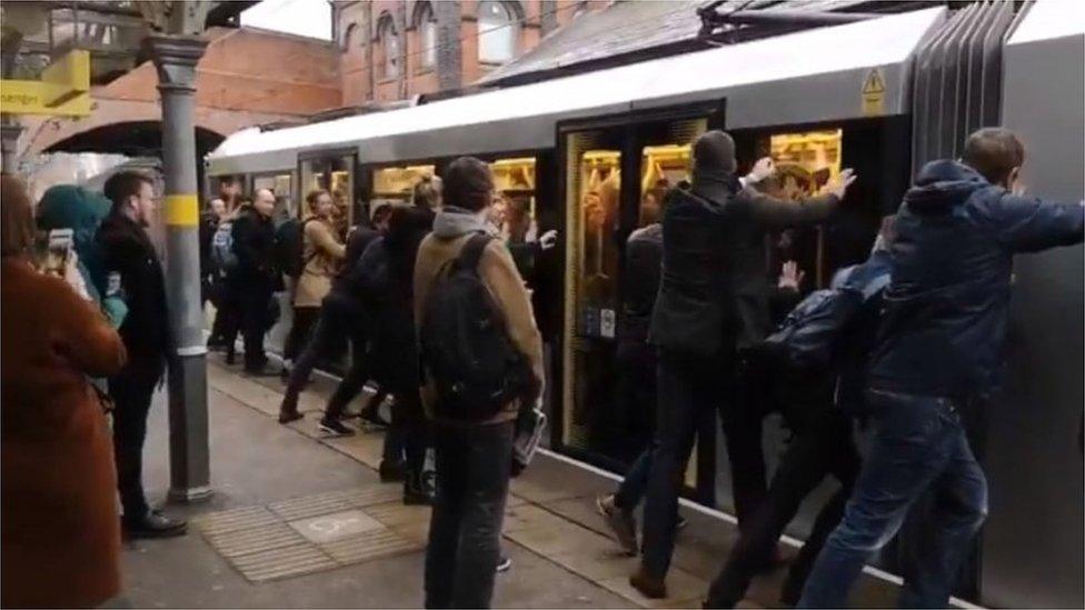 Passengers push doors shut on tram