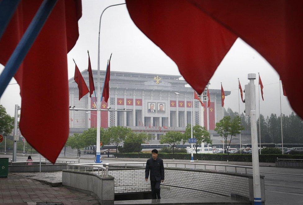 A North Korean man walks out of an underpass while seen framed by the Workers' Party flags, in front of the April 25 House of Culture, the venue for the 7th Congress of the Workers' Party of Korea on Friday, 6 May 2016, in Pyongyang, North Korea.