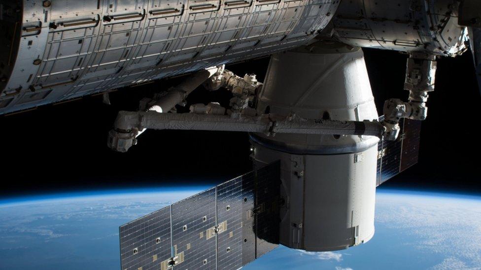 Photograph of SpaceX cargo craft attached to the ISS, delivering supplies