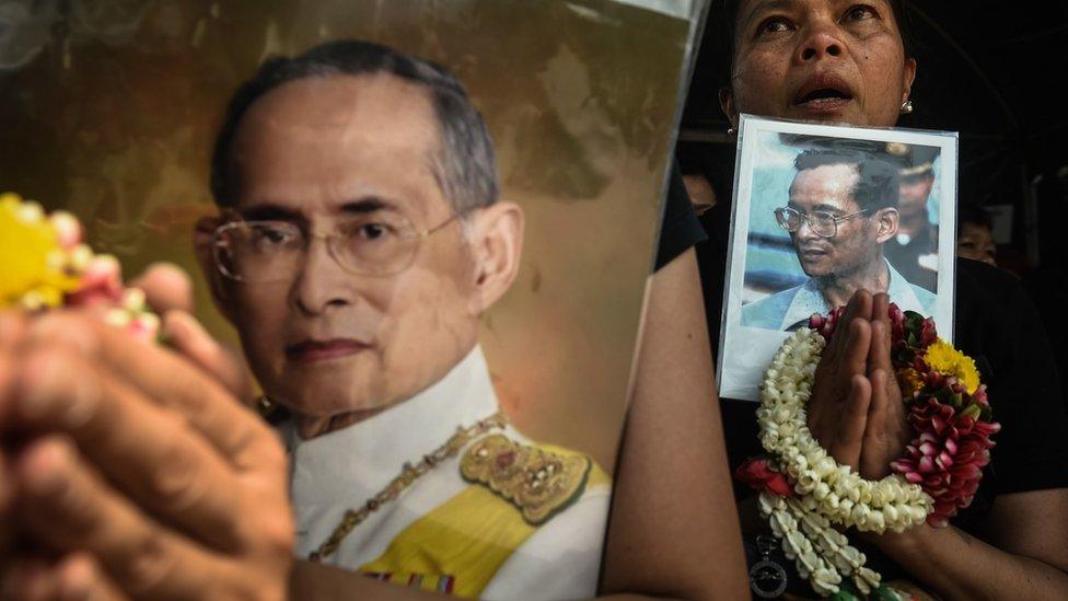 A woman prays with an image of the late Thai King Bhumibol Adulyadej after a religious ceremony to mark the placing of the cornerstones of his funeral pyre, next to the Grand Palace in Bangkok on 27 February 2017