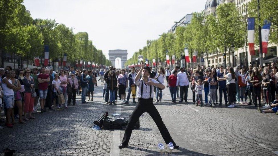 A man performs during a street show on the Champs Elysees in Paris (08 May 2016)