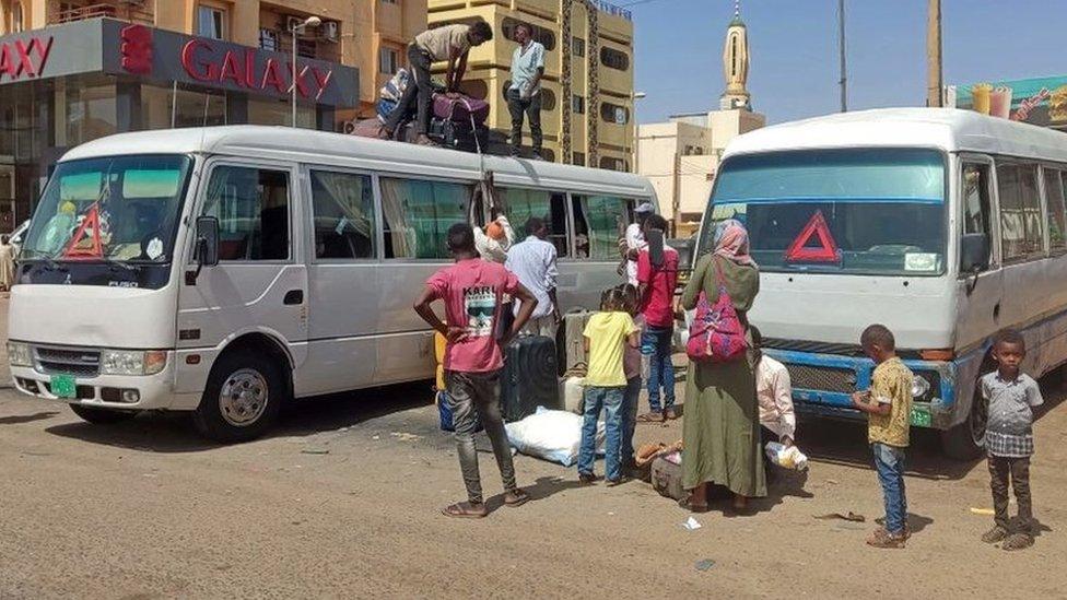 People board a bus as they evacuate southern Khartoum on May 23, 2023 after a one-week ceasefire between Sudan's army and paramilitary Rapid Support Forces officially went into force