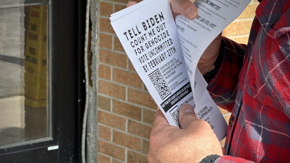 Khalid Turaani held flyers on Monday that encouraged people not to vote for Joe Biden