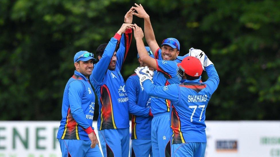 Afghan cricketers celebrate after taking the wicket of Ireland batsman Andrew Poynter