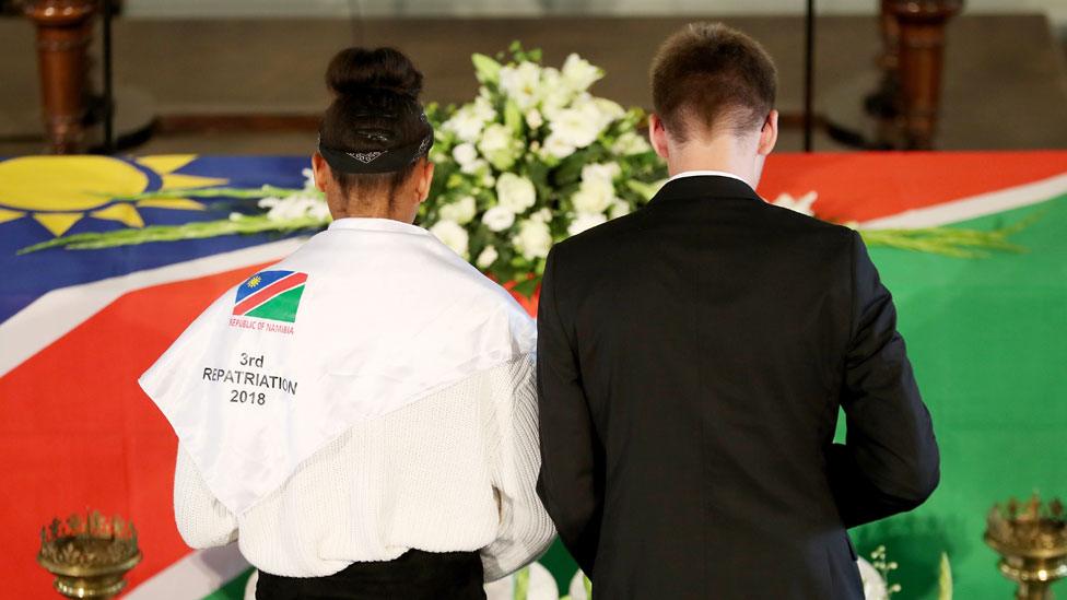 Two people bowing their heads during the service in Berlin, German