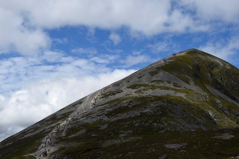 Pilgrims ascend and descend Croagh Patrick holy mountain during an annual Catholic pilgrimage near Lecanvey, Ireland