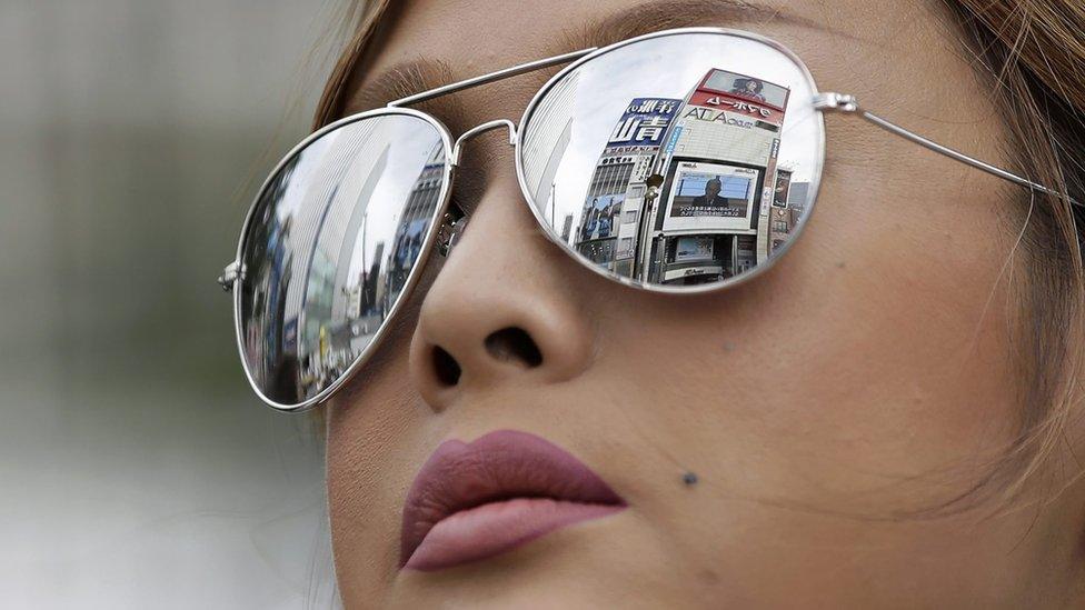 A large screen broadcasting Japanese Emperor Akihito"s video message on his thoughts is reflected on a pedestrian"s sunglass as she watches the video message, in Tokyo, Japan, 08 August 2016.