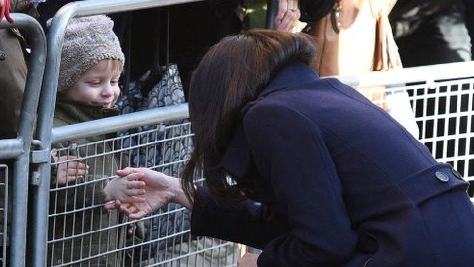 a little boy shakes Meghan Markle's hand