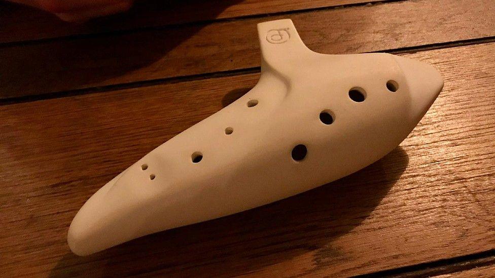 An Italian ocarina lying on a wooden table.