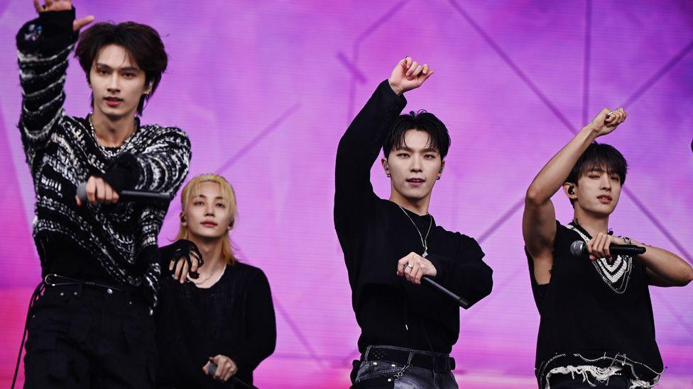 Four members of K-pop boy band Seventeen, dancing on stage at Glastonbury 2024