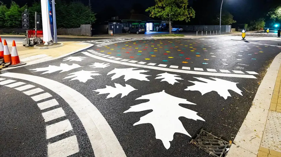 The crossing with an oak leaf pattern painted onto the roundabout and various hand prints inside the roundabout.