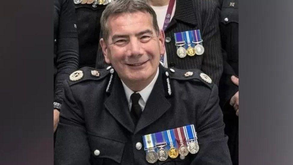 Nick Adderley with short dark hair in a police uniform