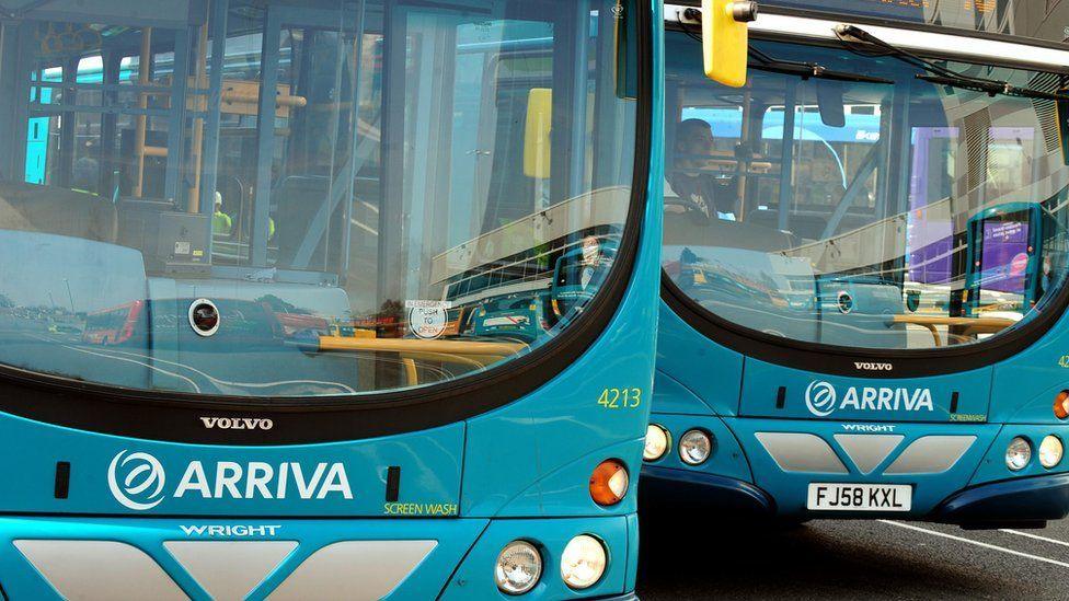 Two cyan Arriva buses parked next to each other.