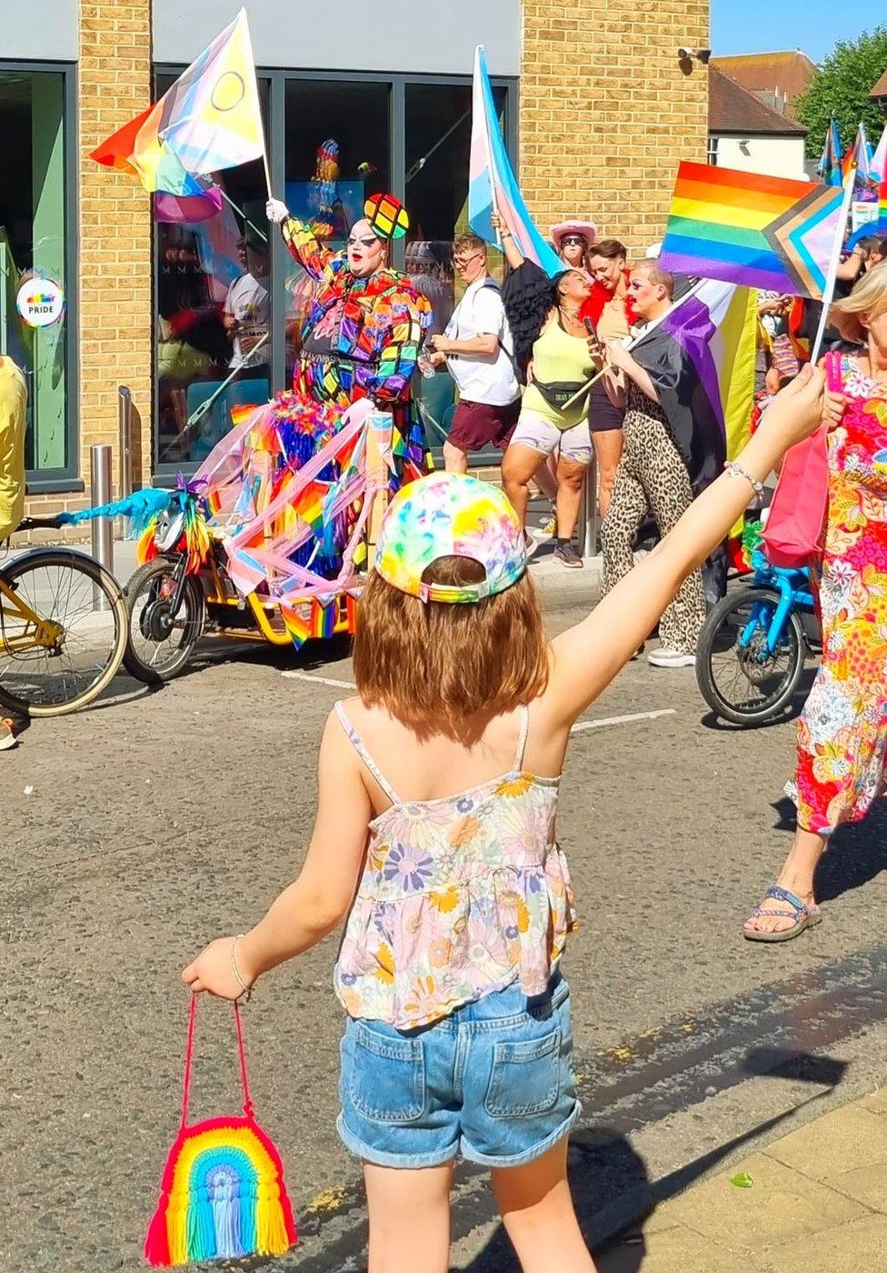 A child waving a flag at Colchester Pride, August, 2022