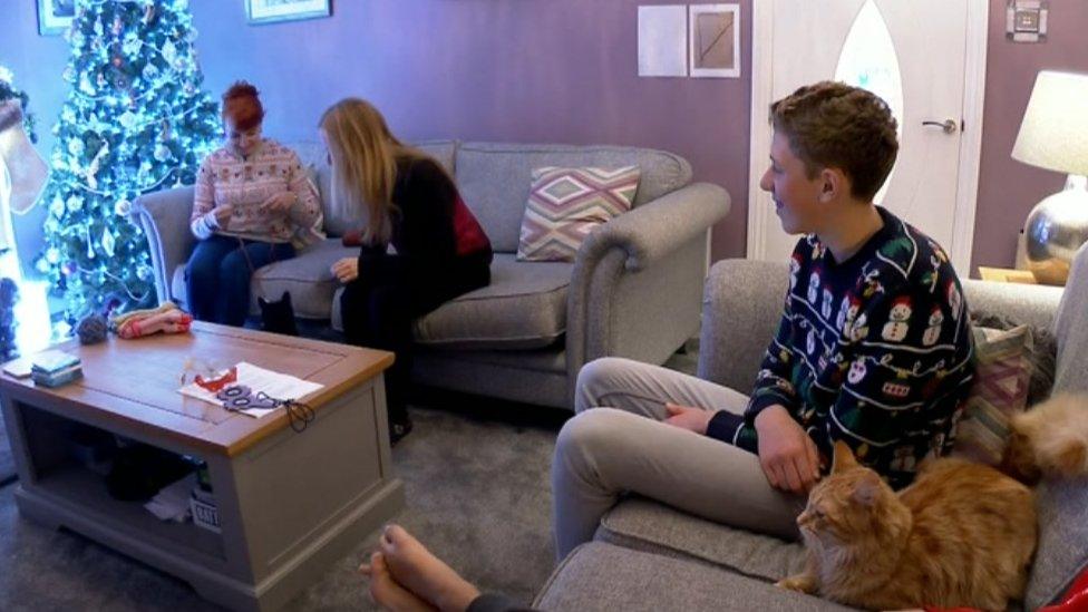 Two women and a boy in a living room