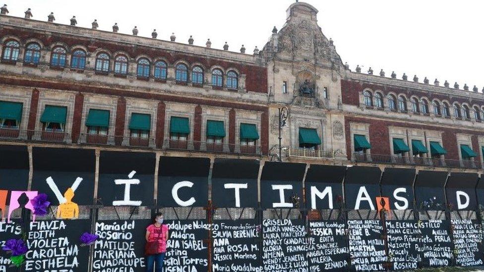 A woman stands next to placards with names of women victims of violence as preparations to the Women"s International Day in Mexico City, Mexico, 07 March 2021