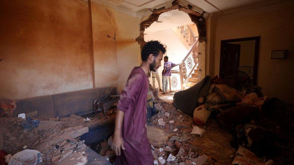 A man looks at the damage inside a house during clashes between the paramilitary Rapid Support Forces and the army in Khartoum, Sudan April 17