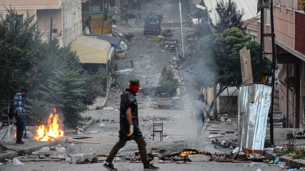 Makeshift barricades fill the streets as left-wing protesters light a fire trying to avoid tear gas used by police to disperse them, in Istanbul, (26 July 2015)