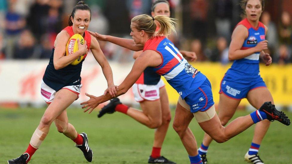 AFL Women's player Daisy Pearce, for the Melbourne Demons, breaks away from an opponent