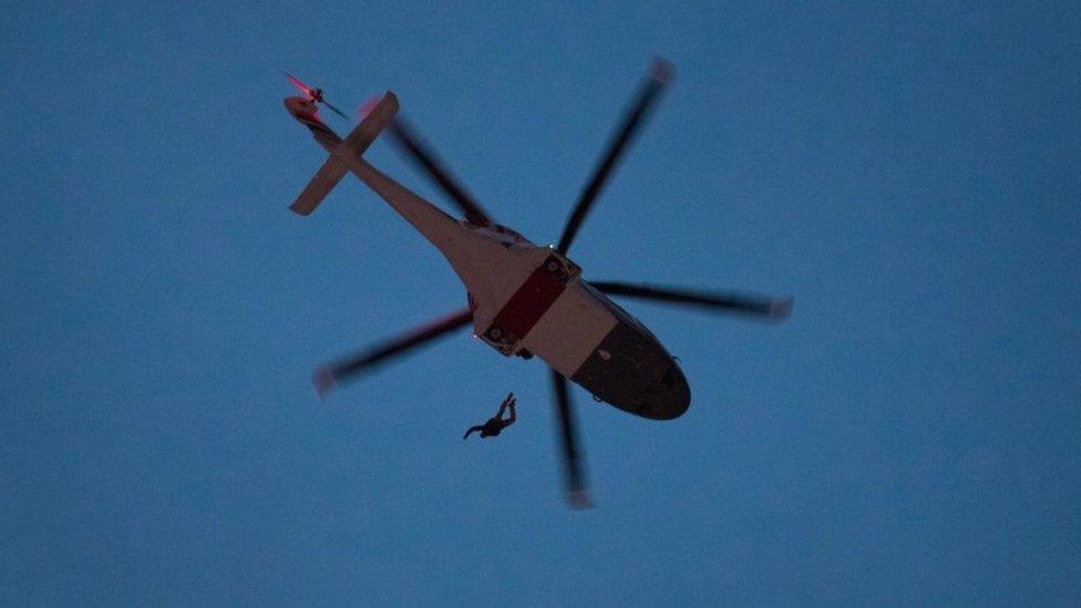 Person jumping out of helicopter