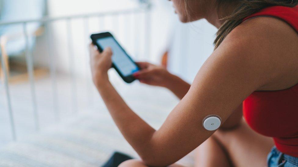 Young woman with diabetes scanning blood sugar levels