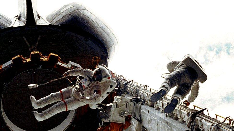 Astronauts Story Musgrave (L) and Don Peterson float in the cargo bay of the space shuttle Challenger during the STS-6 mission 7 April 1983.