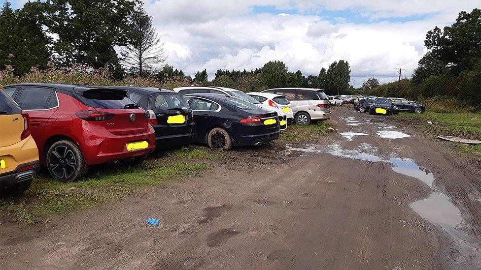 Cars parked on muddy field