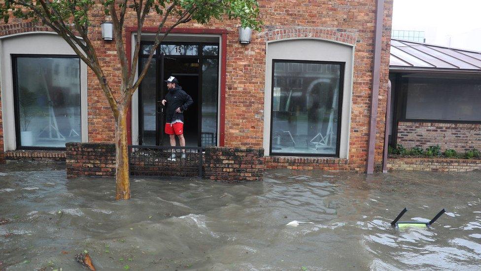 Hurst Butts looks out at a flooded street in front of his business as Hurricane Sally passes through the area on September 16, 2020 in Pensacola, Florida