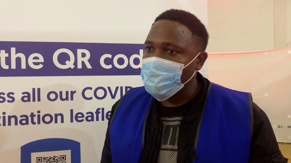 Man standing in front of vaccination centre sign