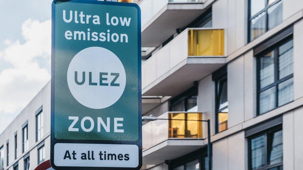 Green ULEZ sign in front of flats