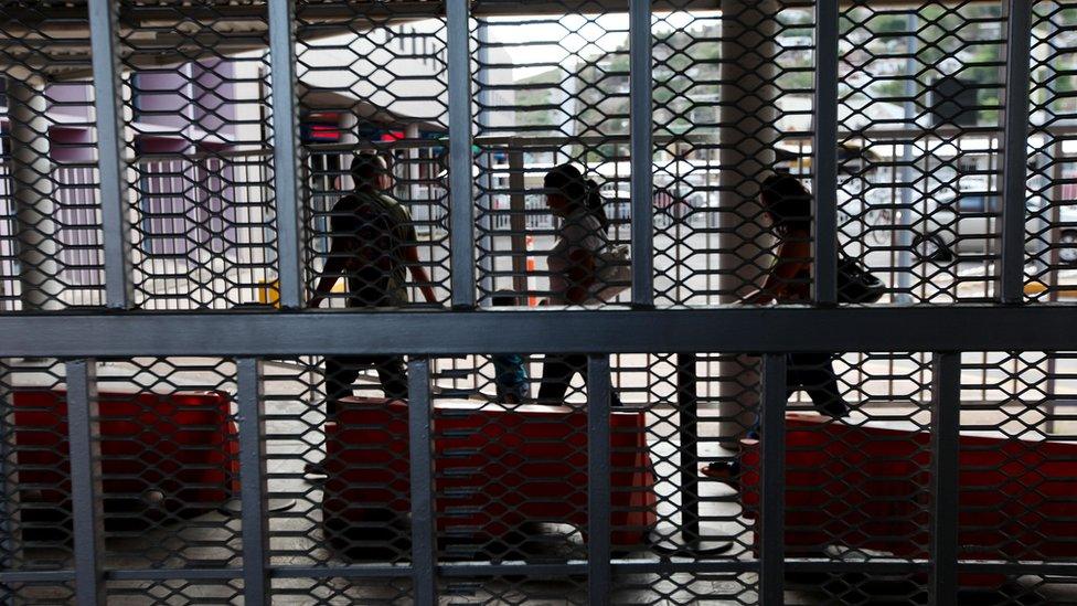 Mexican nationals walk with their luggage through the U.S-Mexico border on July 7, 2012 in Nogales