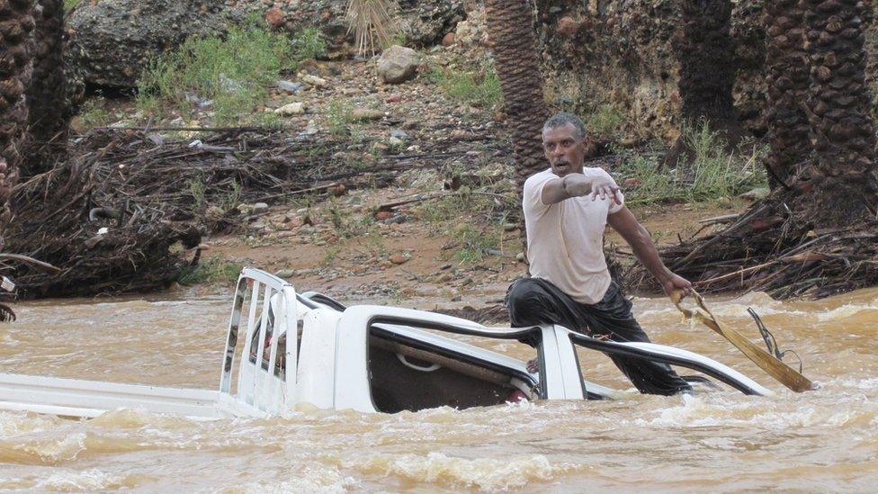 A man tries to save a vehicle from being swept away from water on the Yemeni island of Socotra (2 November 2015)