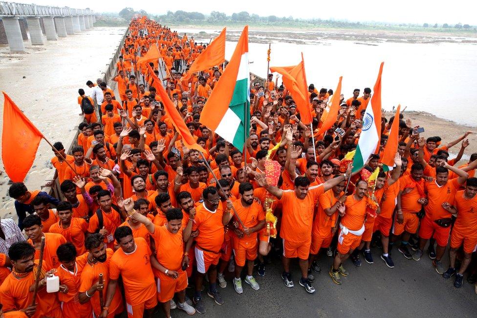 Kanwariyas gather after collecting water from the river Narmada during their annual pilgrimage on 4 August 2018.