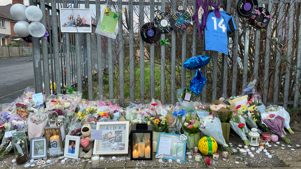 Flowers laid on a fence at the site of the stabbings in Knowle West