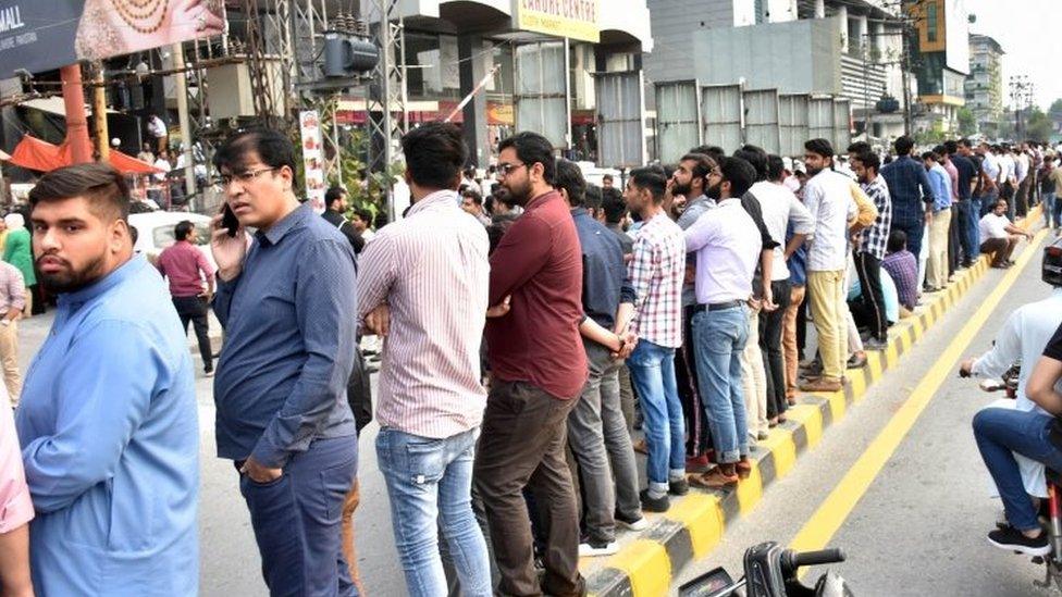 People gather outside offices and shops in Mirpur, Pakistan-administered Kashmir. Photo: 24 September 2019