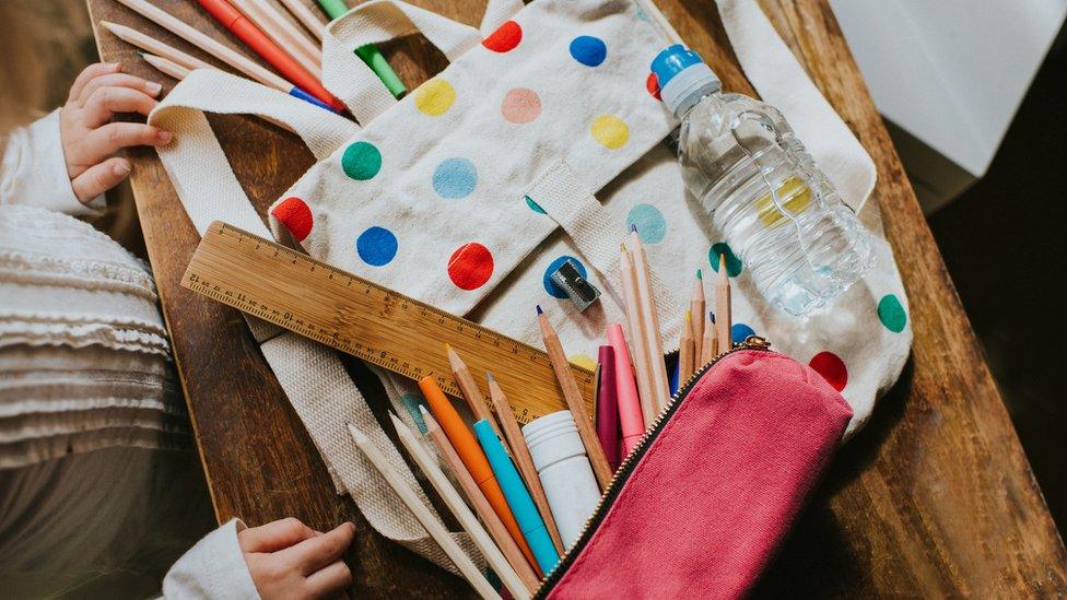 Child looking at a Spotty Schoolbag with Stationary Surrounding