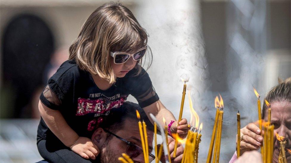 A little girl lights a candle for Easter in Skopje